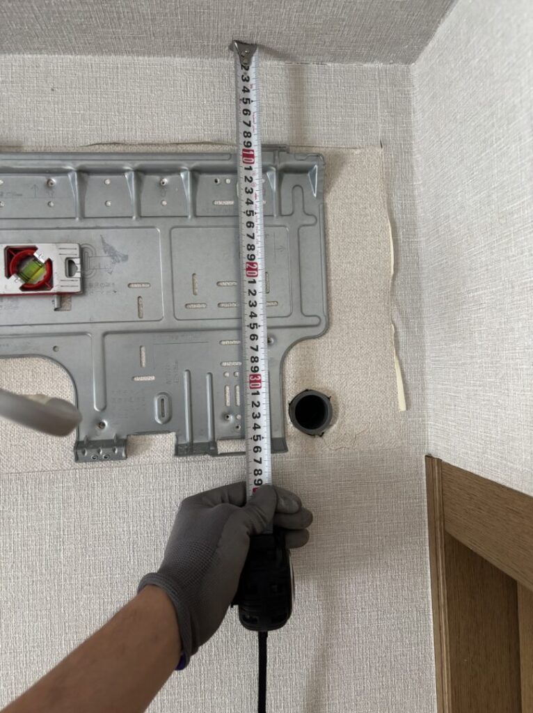 ドレンホースの排水穴の位置が高く逆勾配になっていた原因、穴の高さを測っている画像